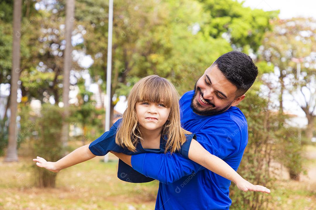 Father and daughter playing in the park. Happy Father's Day Dad playing on a plane with his daughter in his arms