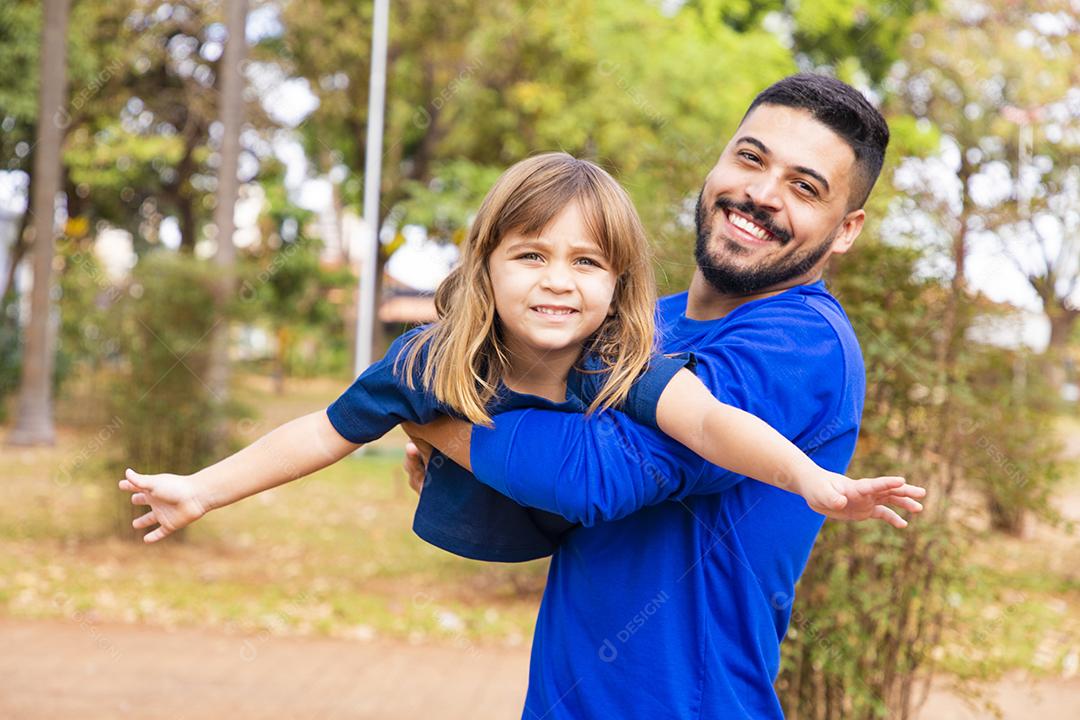 Pai e filha brincando no parque. Feliz Dia dos Pais Pai jogando em um avião com sua filha nos braços