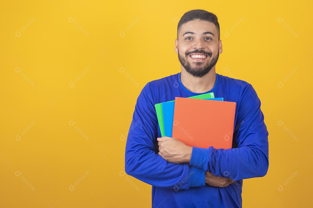 Menino jovem estudante sobre fundo amarelo. menino estudante feliz