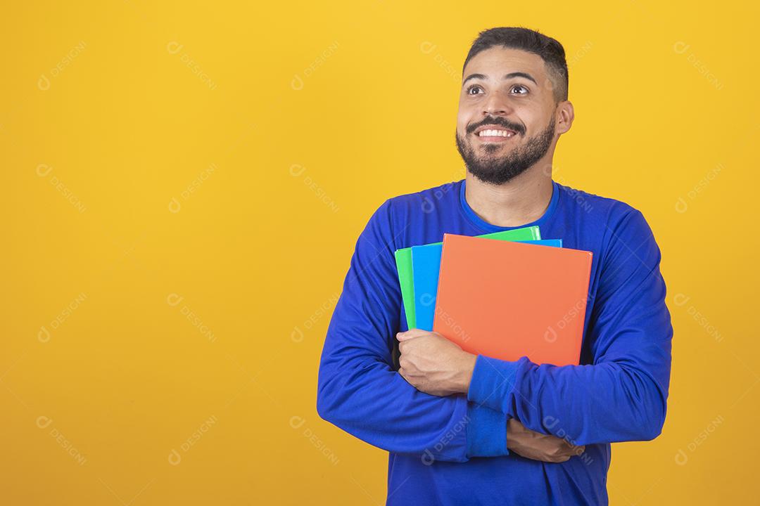 Menino jovem estudante sobre fundo amarelo. menino estudante feliz