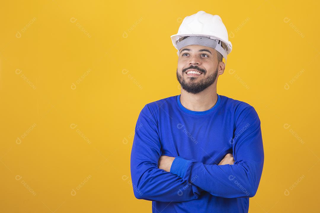 Homem jovem arquiteto com capacete com braços cruzados
