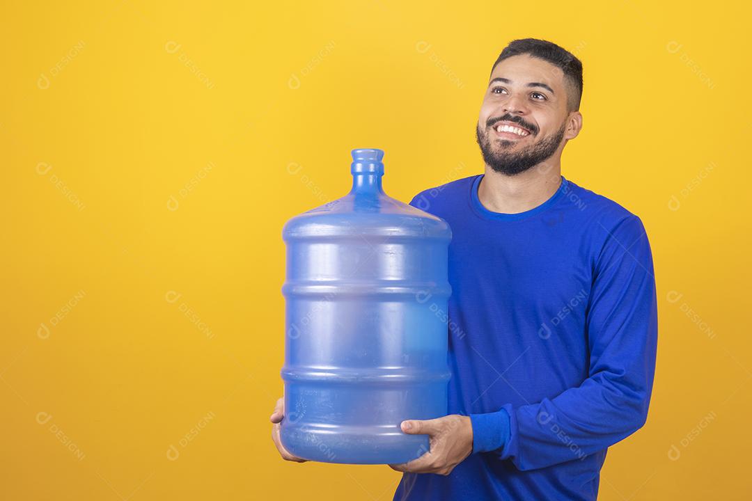 Entregador segurando garrafa de água vazia em fundo amarelo