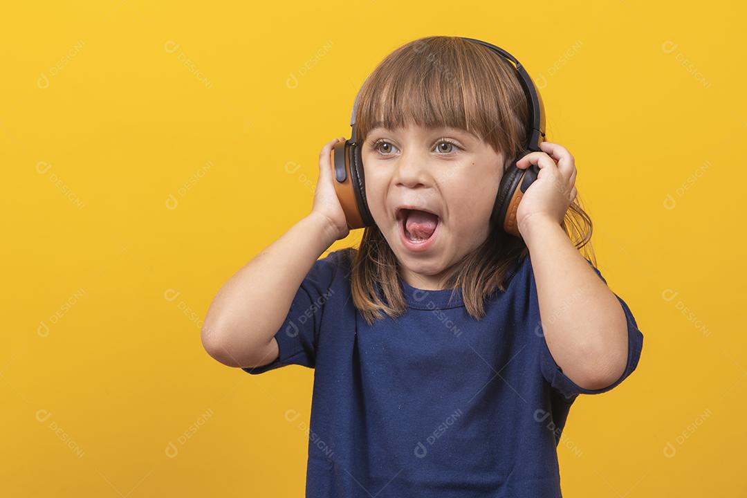 menina caucasiana bonitinha com fones de ouvido ouvindo música em fundo amarelo
