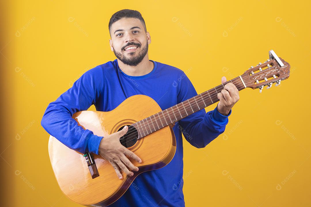 young guitar playing on yellow background