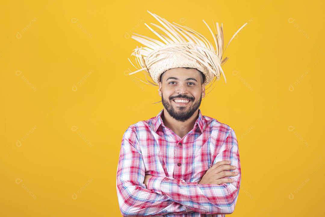 Homem brasileiro vestindo roupas típicas para a Festa Junina com os braços cruzados