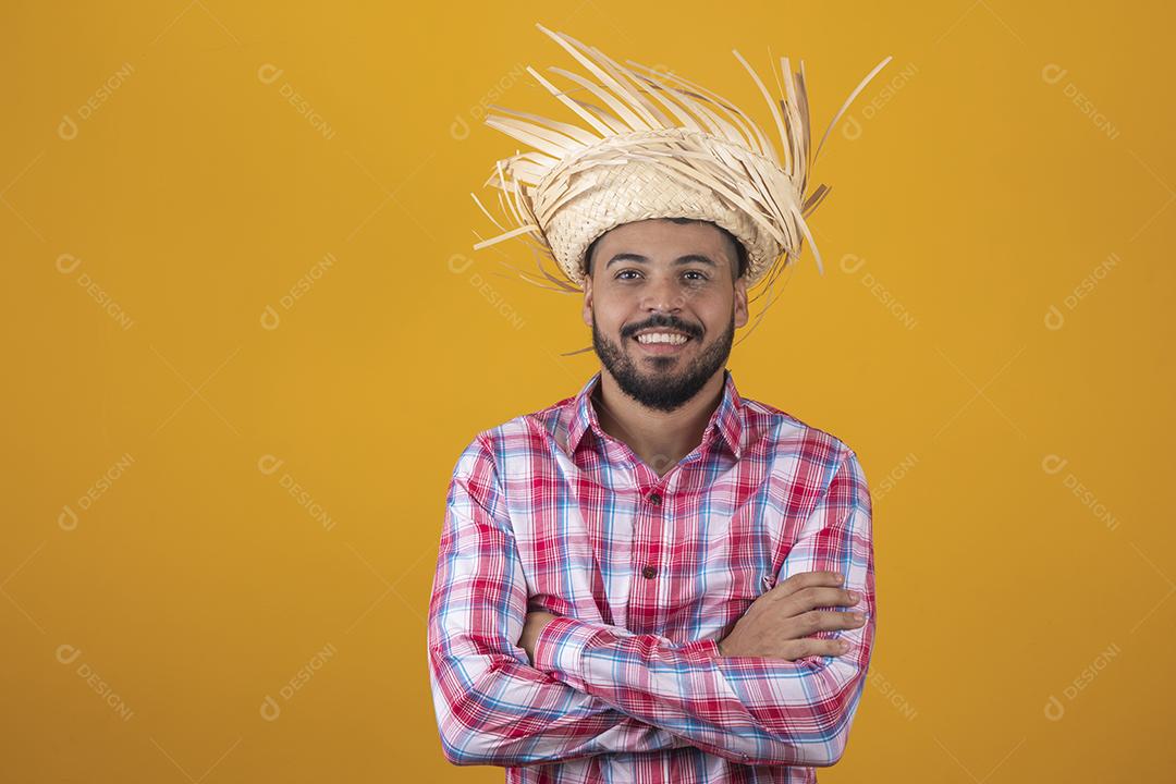 Homem brasileiro vestindo roupas típicas para a Festa Junina com os braços cruzados