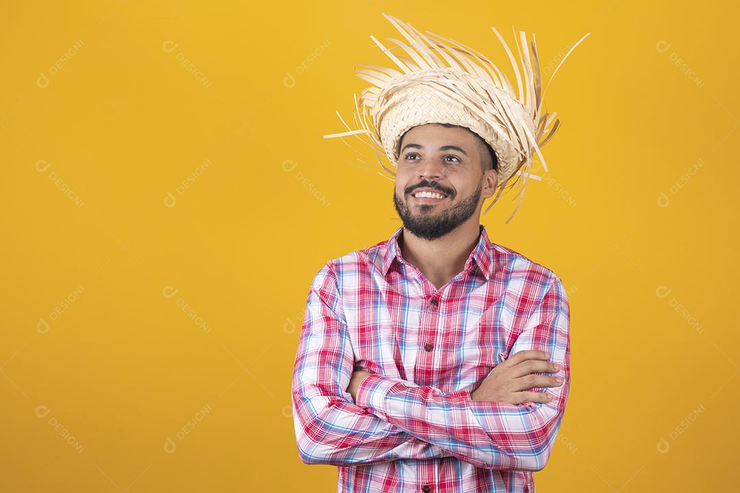 Homem brasileiro vestindo roupas típicas para a Festa Junina com os braços cruzados