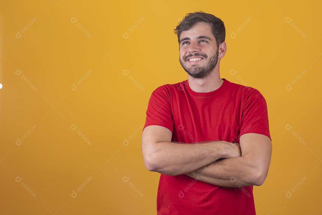 Menino bonito sorrindo olhando para a câmera com os braços cruzados.