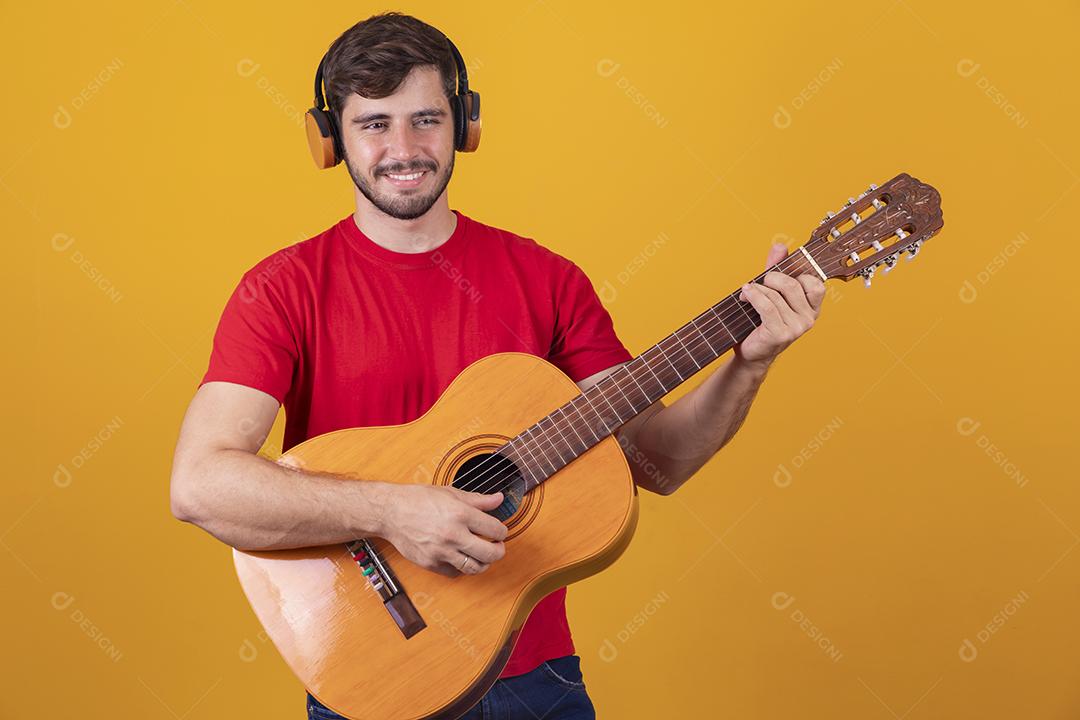 jovem tocando guitarra em fundo amarelo