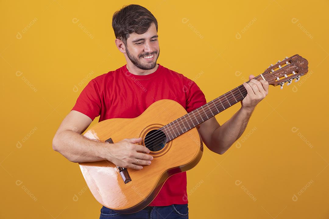 jovem tocando guitarra em fundo amarelo