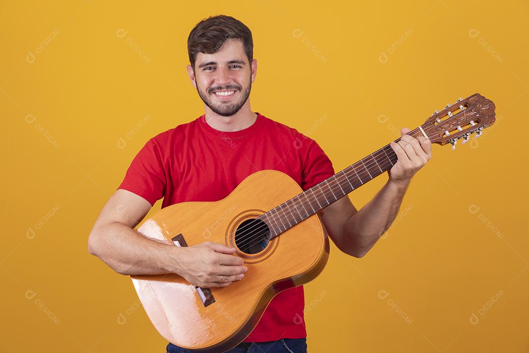 jovem tocando guitarra em fundo amarelo