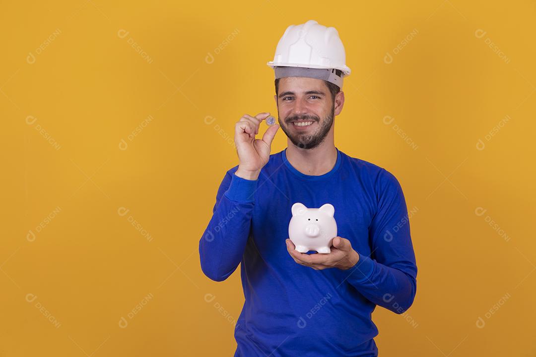 menino jovem arquiteto com um cofrinho nas mãos. Conceito de poupança para o trabalho