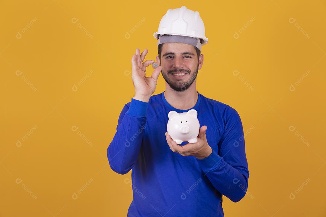 menino jovem arquiteto com um cofrinho nas mãos. Conceito de poupança para o trabalho