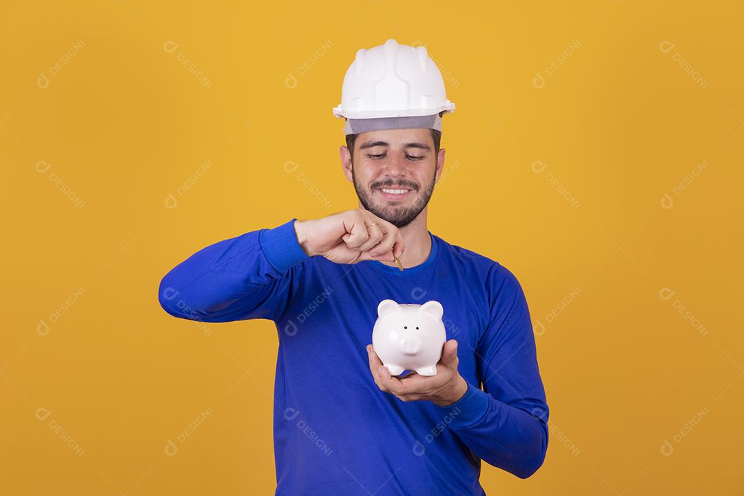 menino jovem arquiteto com um cofrinho nas mãos. Conceito de poupança para o trabalho