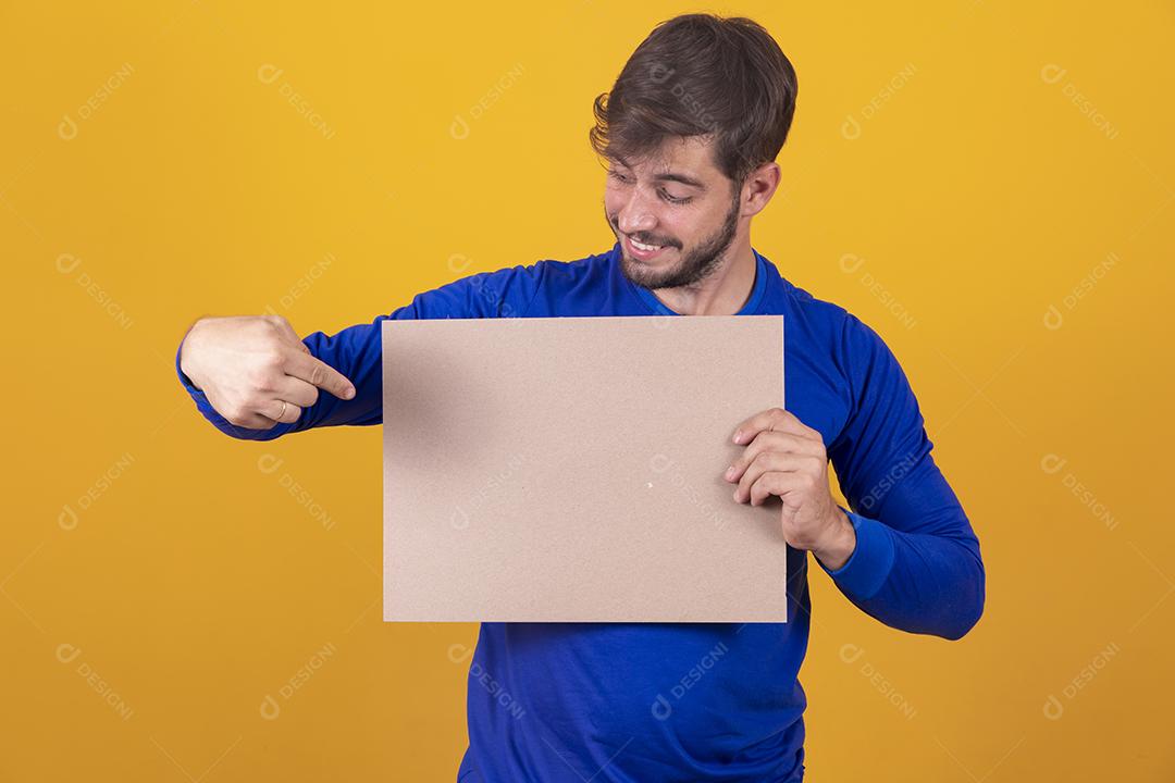 Homem jovem segurando um mini carrinho de compras