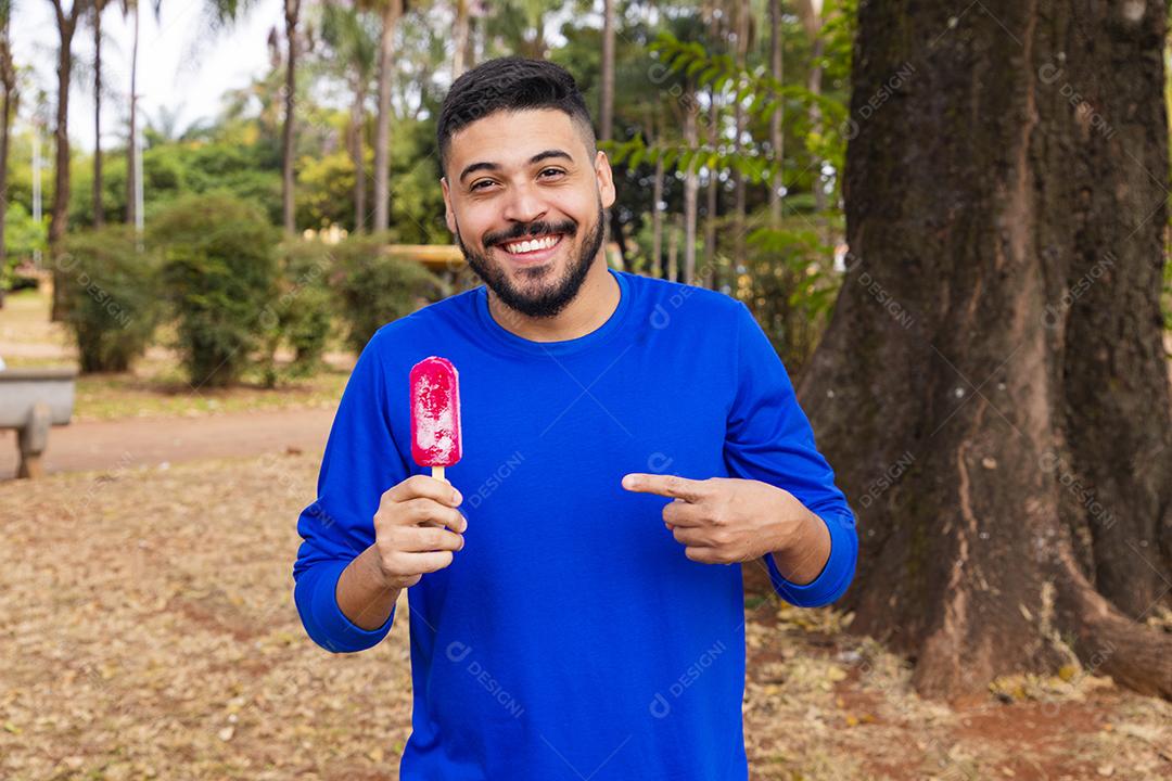 menino no parque com um picolé para se refrescar