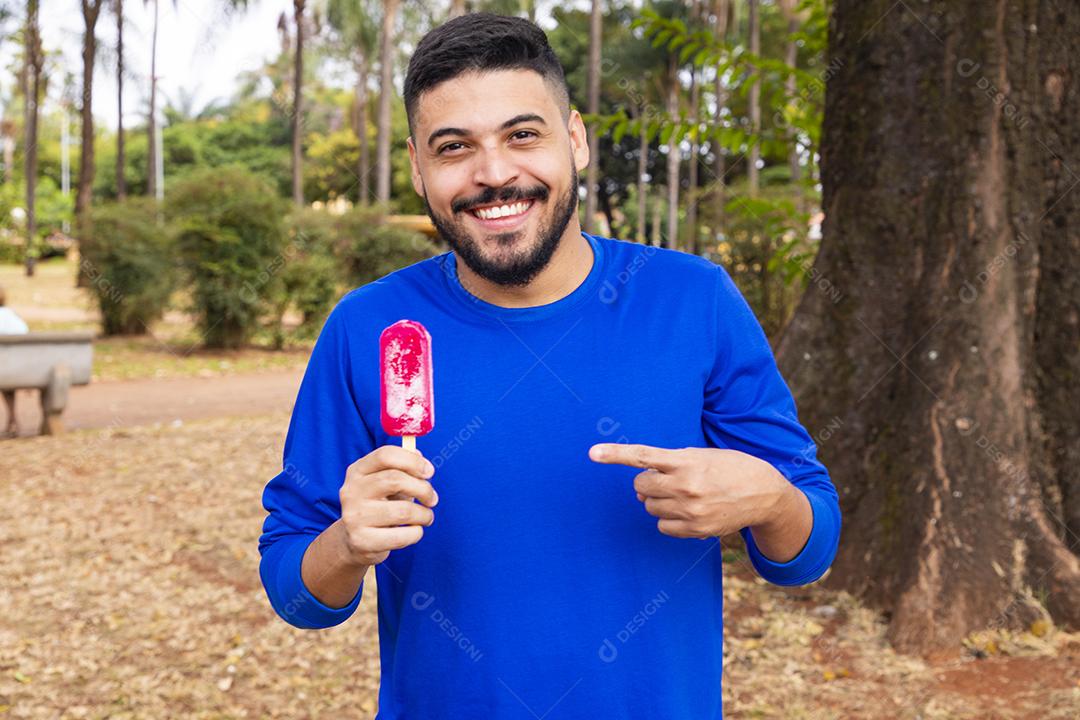 menino no parque com um picolé para se refrescar