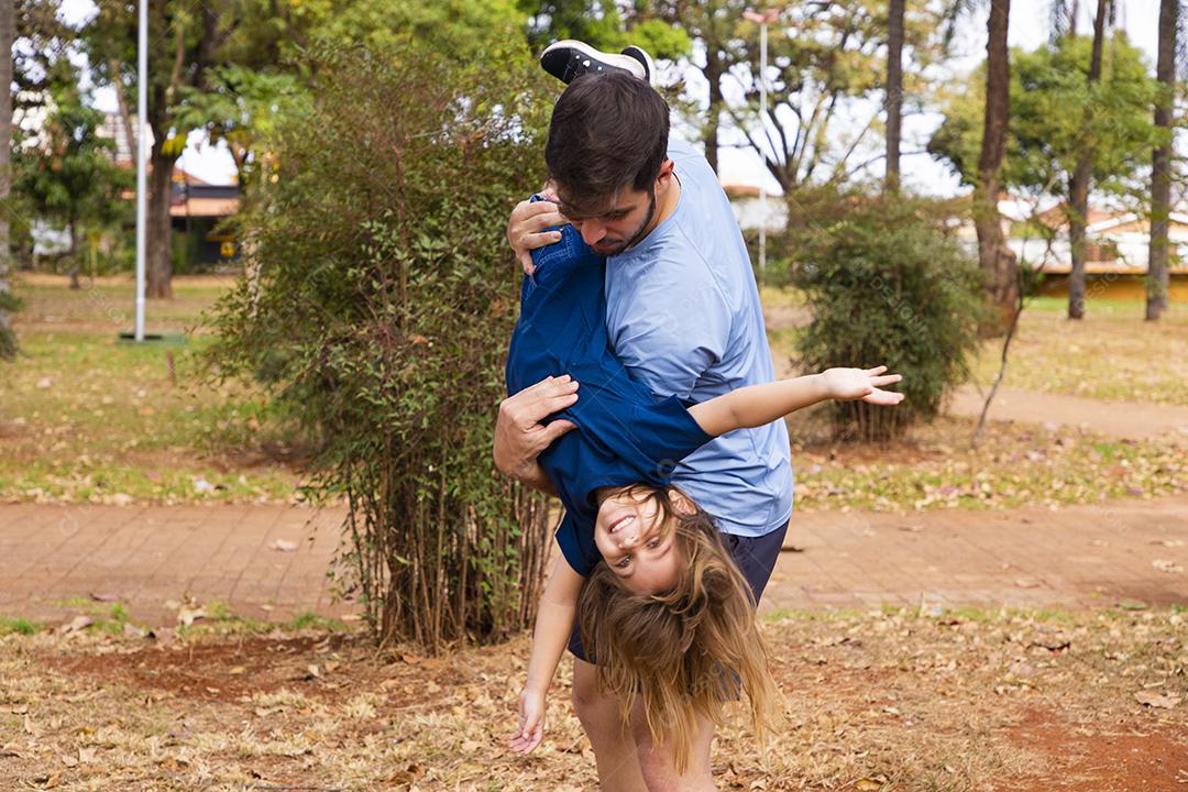 Pai e filha brincando no parque. Feliz Dia dos Pais Pai jogando em um avião com sua filha nos braços