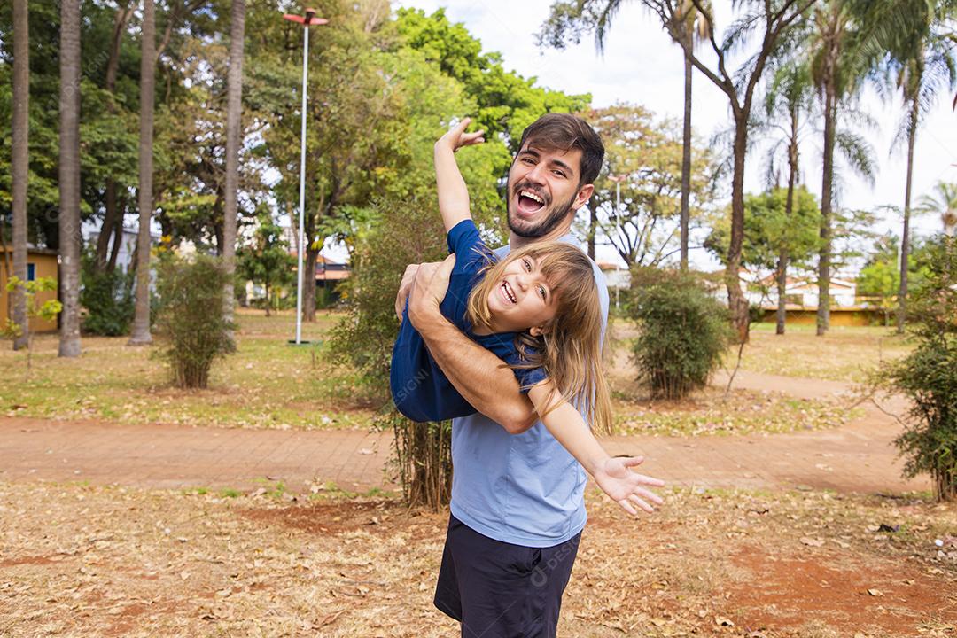 Pai e filha brincando no parque. Feliz Dia dos Pais Pai jogando em um avião com sua filha nos braços