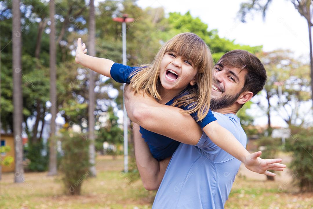 Pai e filha brincando no parque. Feliz Dia dos Pais Pai jogando em um avião com sua filha nos braços