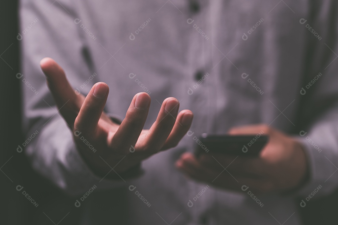 Pessoa que usam smartphones com tons escuros.