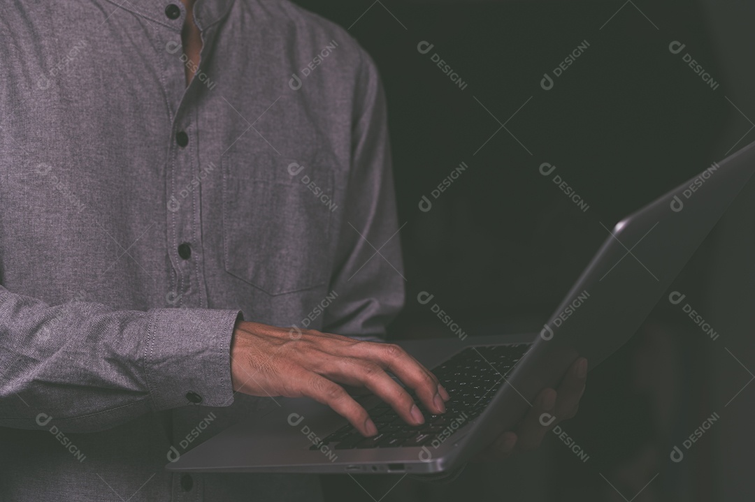 Homem em pé usando um laptop