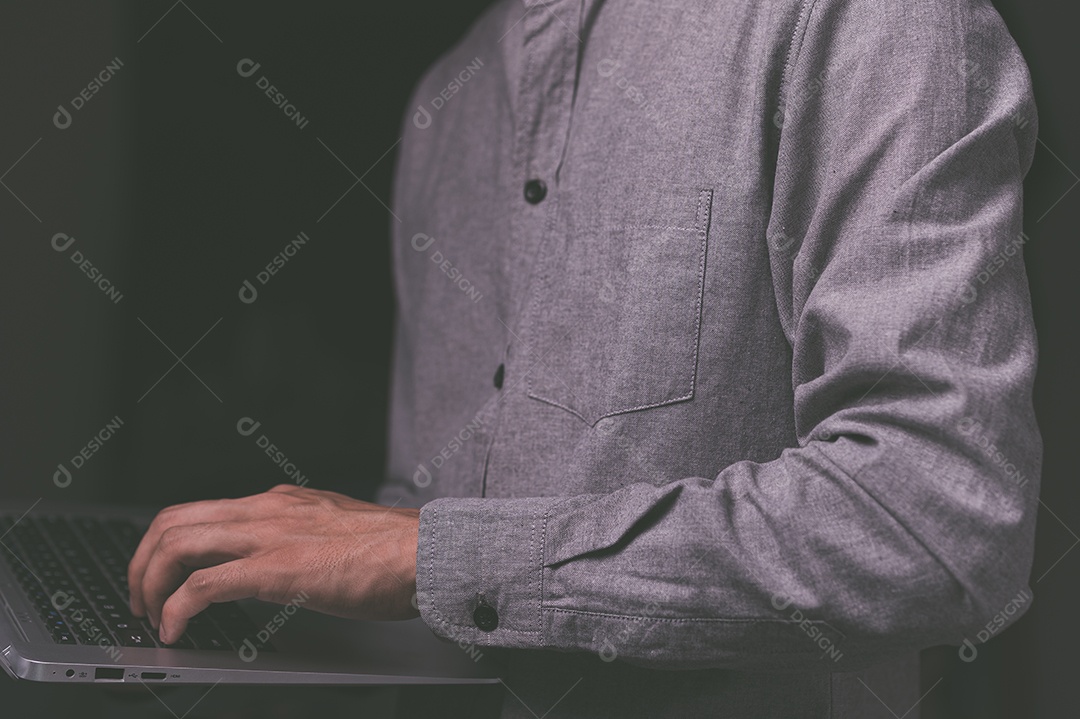 Homem em pé usando um laptop