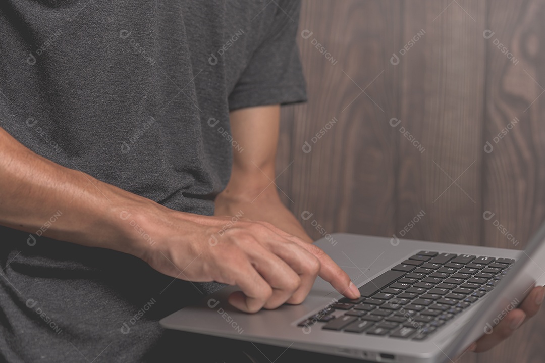 Homem em pé usando um laptop