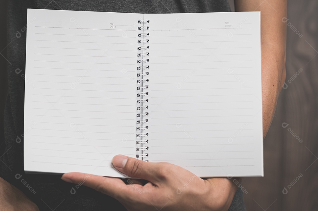 Homem segurando um caderno de papel
