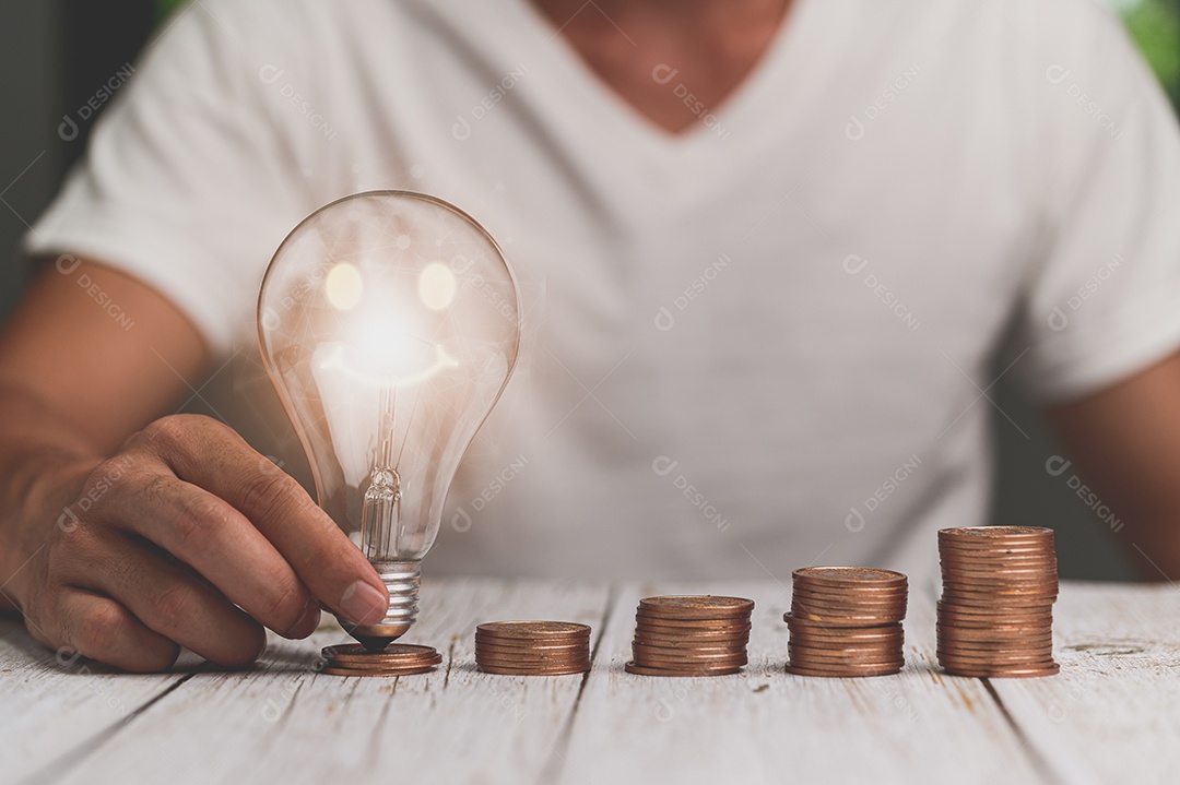 Empresário segurando a ideia de pilha de dinheiro de lâmpada economizando energia