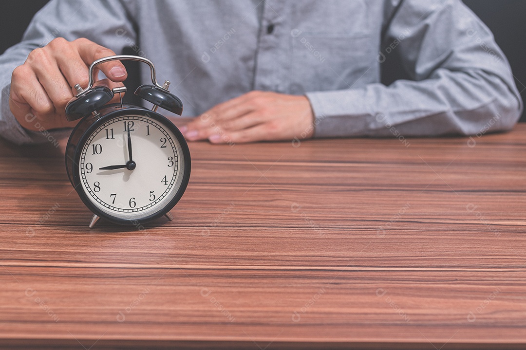 Mão humana segura um relógio mostrando a hora