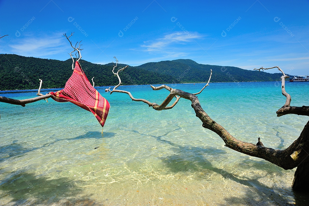 Tecido vermelho na praia e céu azul