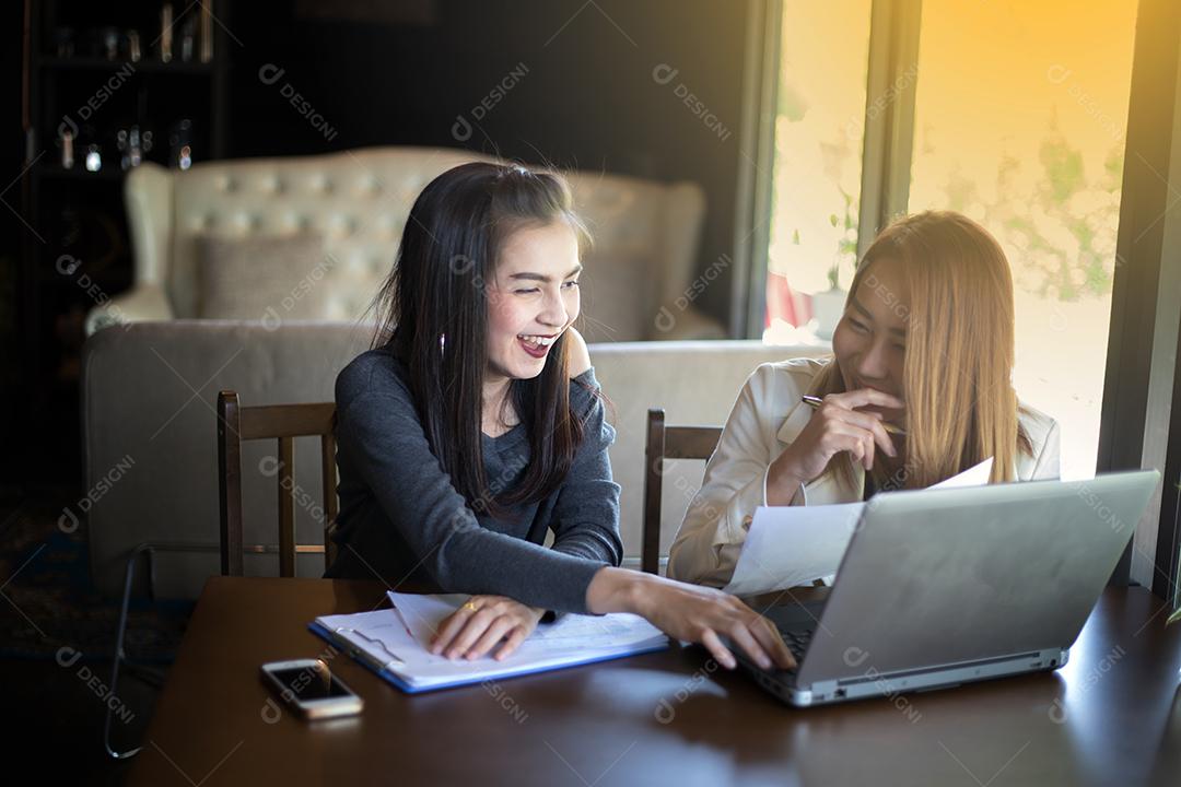 Duas mulheres de negócios asiáticas usando notebook trabalhando e discussão do importante contrato no escritório, foco suave