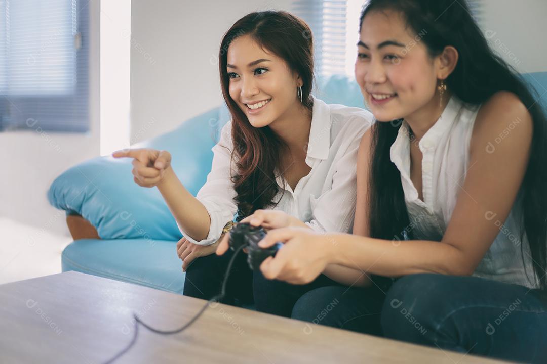 duas mulheres amigas competitivas jogando videogame e animadas felizes alegres em casa