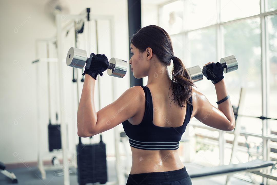 bela mulher apto muscular exercitando a construção de músculos e fitness mulher fazendo exercícios no ginásio. Aptidão - conceito de estilo de vida saudável, foco suave