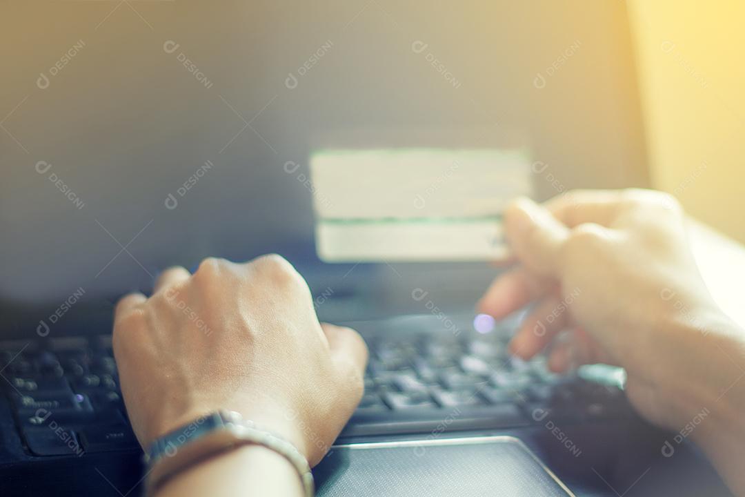 mulher asiática usando laptop e cartão de crédito compras on-line, foco seletivo na mão, foco suave e tom vintage