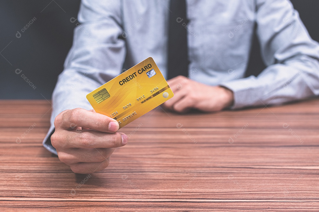 Homem segurando um cartão de crédito