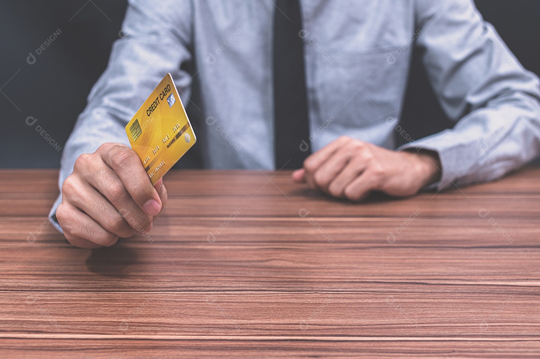 Homem segurando um cartão de crédito