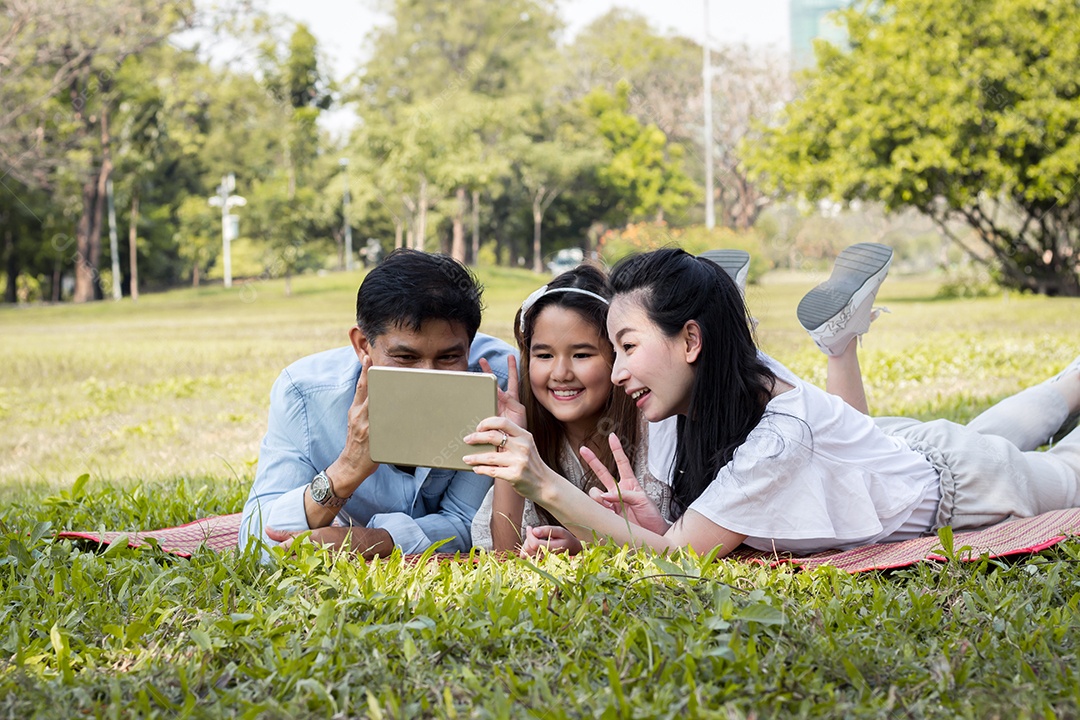 Pais e filhos estão jogando o tablet no tatame.