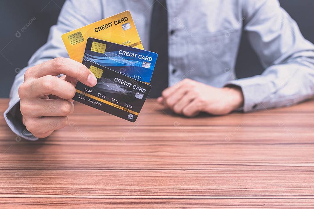 Homem segurando um cartão de crédito