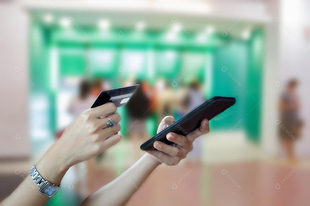 mulher asiática usando telefone inteligente e cartão de crédito compras on-line na mão