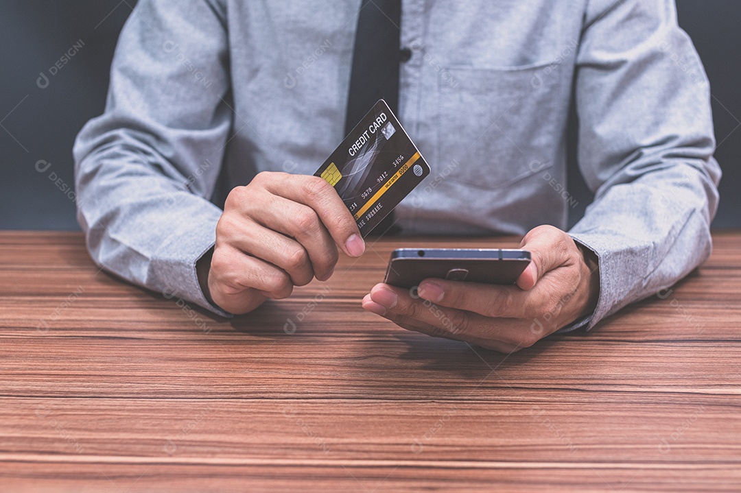 Homem segurando um cartão de crédito