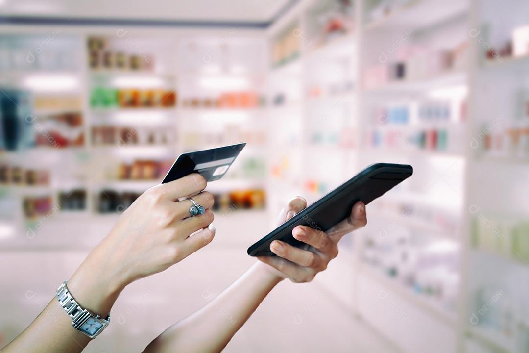 mulher asiática usando telefone inteligente e cartão de crédito compras on-line na mão