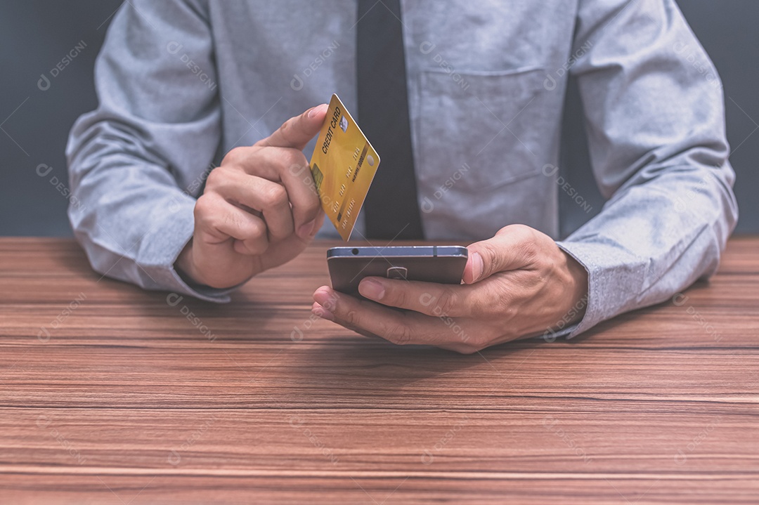 Homem segurando um cartão de crédito
