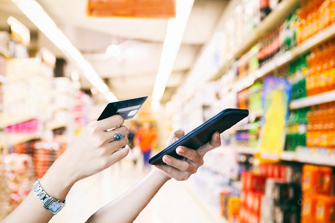 mulher asiática usando telefone inteligente e cartão de crédito compras on-line, foco seletivo na mão