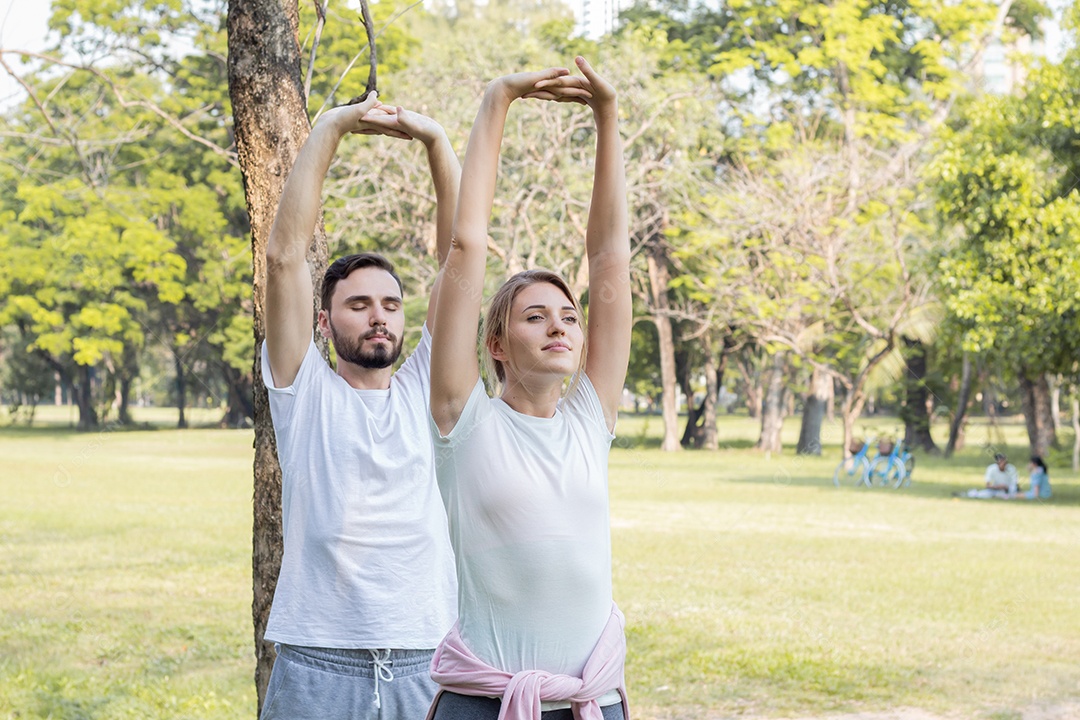 Casais estão se exercitando no parque.