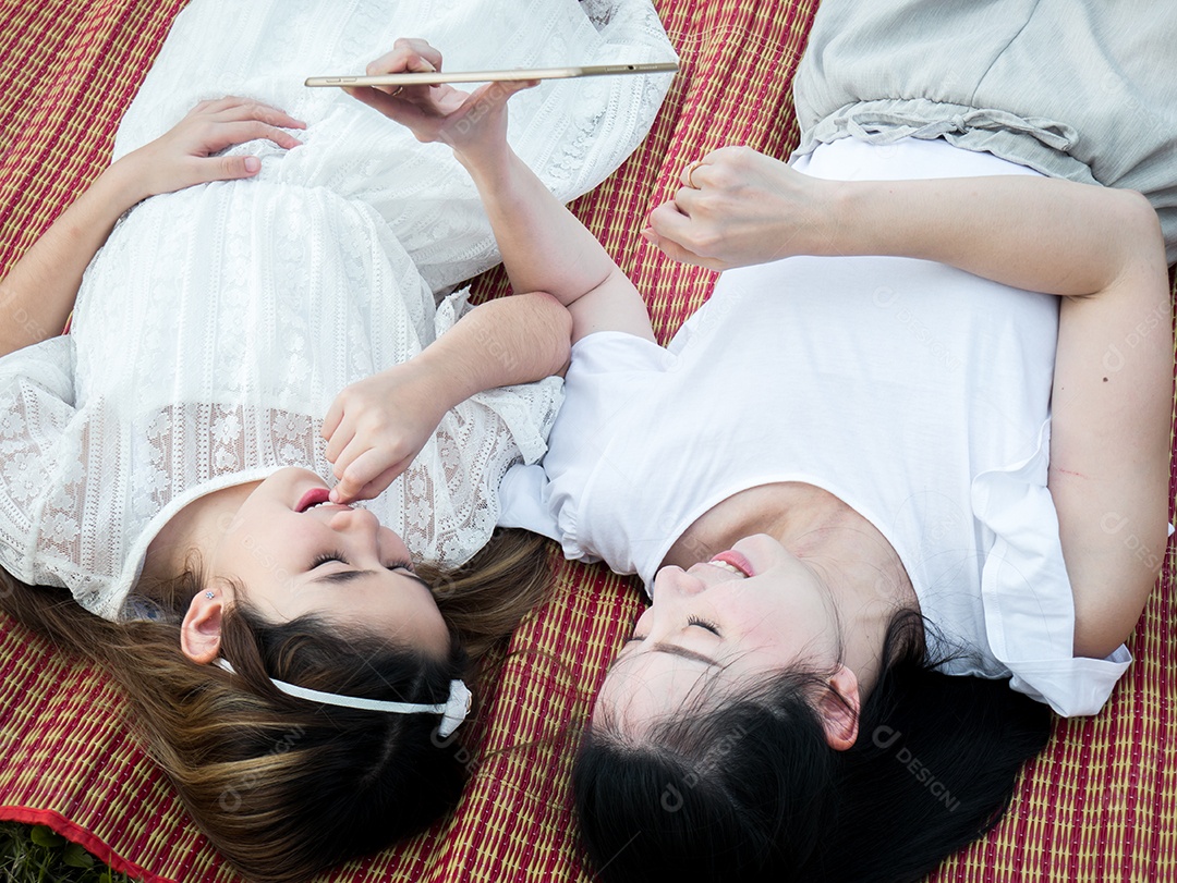 Mãe e filhos estão jogando o tablet no tatame.