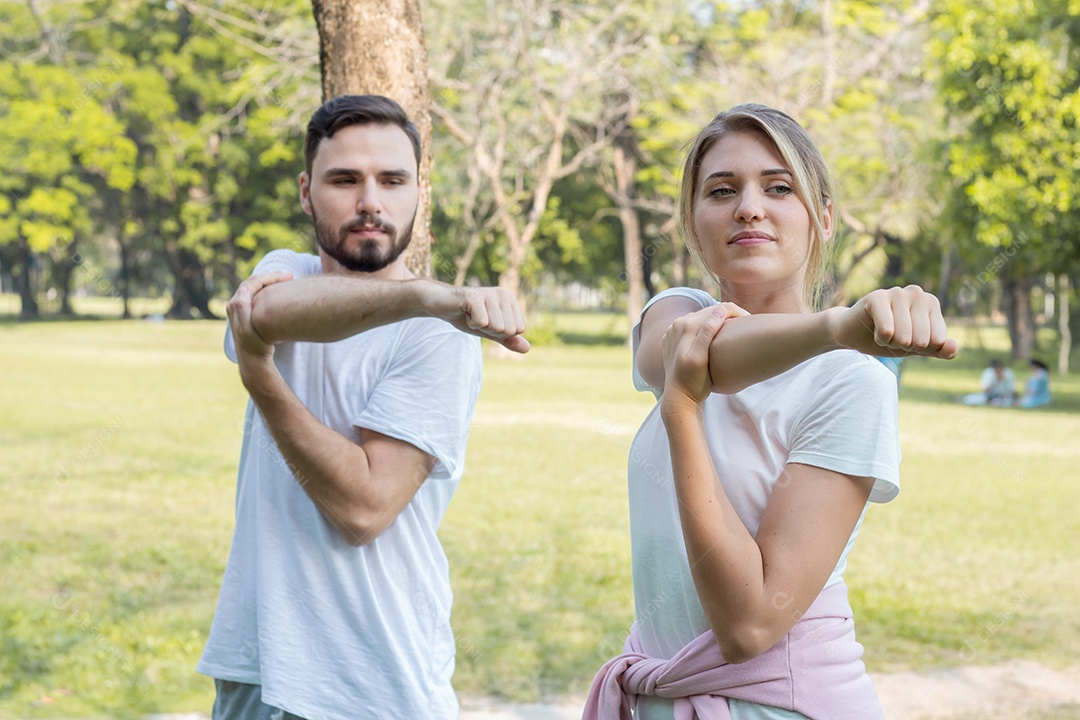 Casais estão se exercitando no parque.