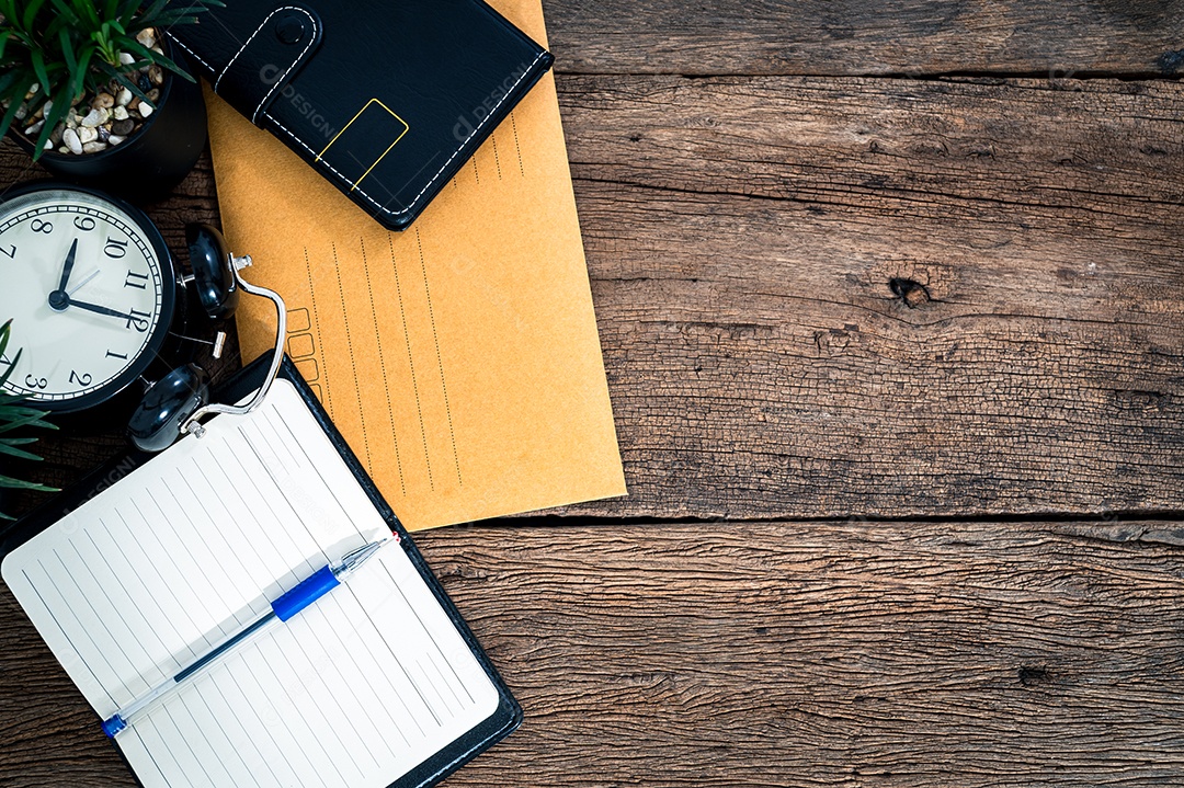 Mesa de trabalho, cadernos, artigos de papelaria e café estão acima da vista