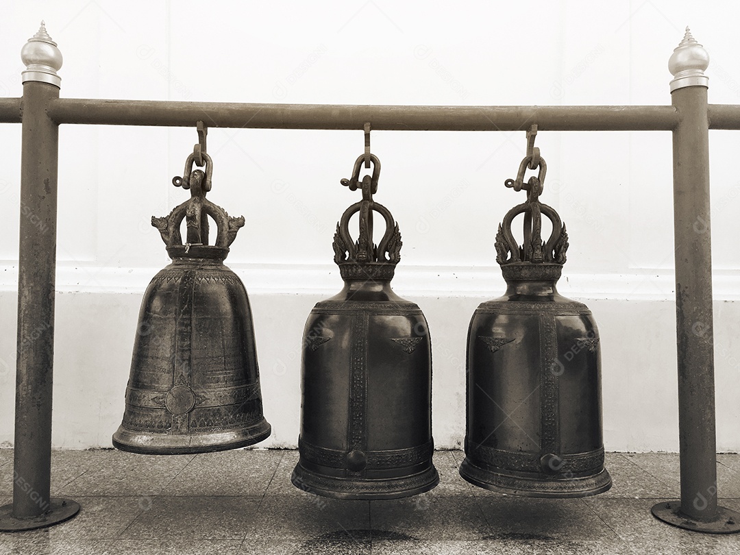 Três sinos antigos pendurados em vigas circulares de aço